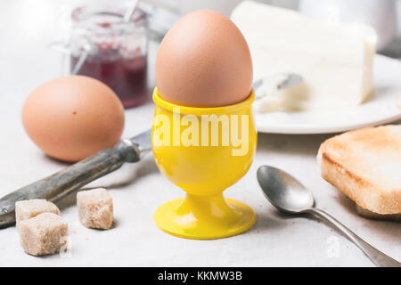 Breakfast with eggs and toasts served with jam and butter over white textile Stock Photo