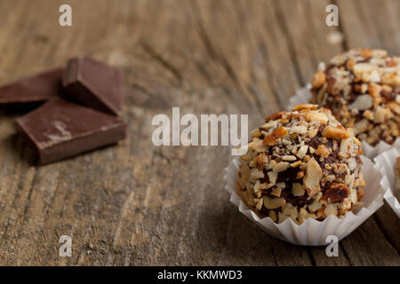 Chocolate Truffles and pieces of black chocolate on old wooden table Stock Photo