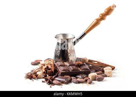 Copper cezve with dark chocolate, cocoa beans, cinnamon and anise isolated over white Stock Photo