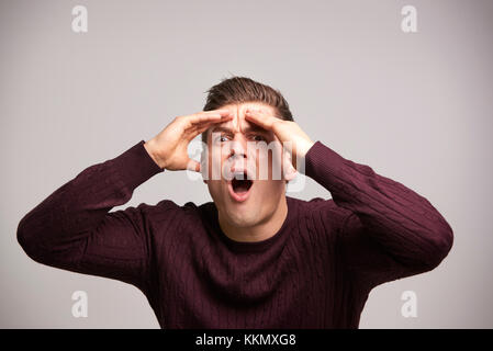 Shocked young white man with hands by his head in disbelief Stock Photo