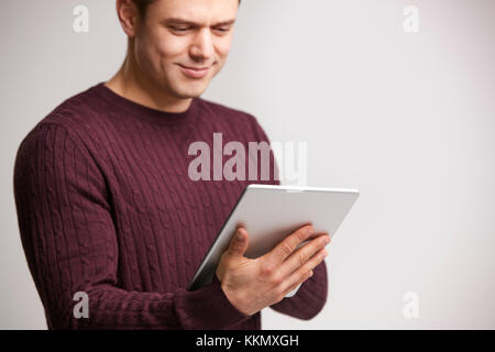 Smiling young white man using a tablet computer Stock Photo