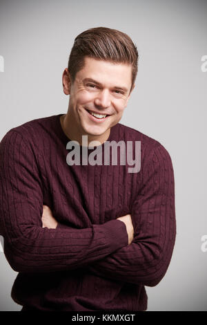 Smiling young white man with arms crossed looking to camera Stock Photo