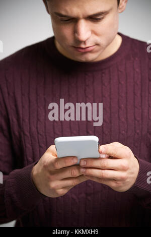 Vertical portrait of a young white man using a smartphone Stock Photo