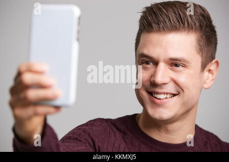 Close up of a young man taking a selfie with his smartphone Stock Photo
