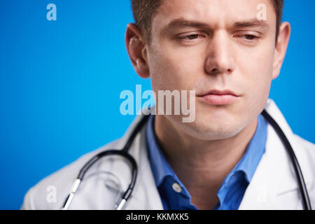 Stressed white male doctor in a lab coat with stethoscope Stock Photo