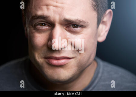 Close up portrait of upset young white man looking to camera Stock Photo