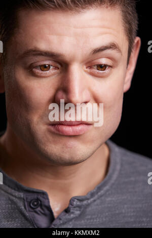 Vertical portrait of crying young white man looking down Stock Photo