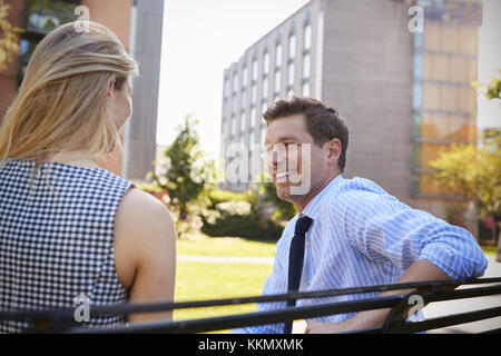 Businessman Talking To Female Colleague On Break In Park Stock Photo