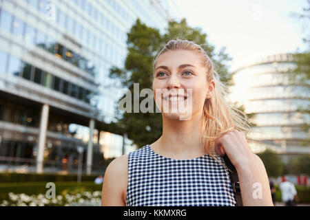 Businesswoman Walking Past Modern City Offices On Way To Work Stock Photo