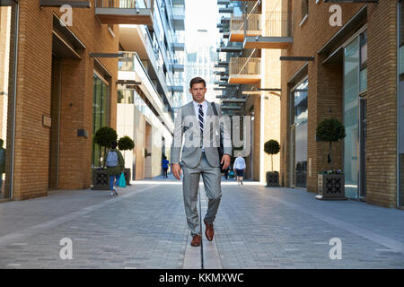 Businessman Walking to Work Along City Street Stock Photo