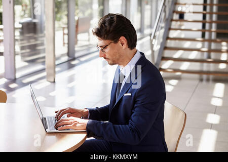 Young professional man using laptop, elevated view Stock Photo