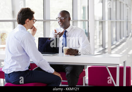 Two businessmen talk during a business meeting Stock Photo