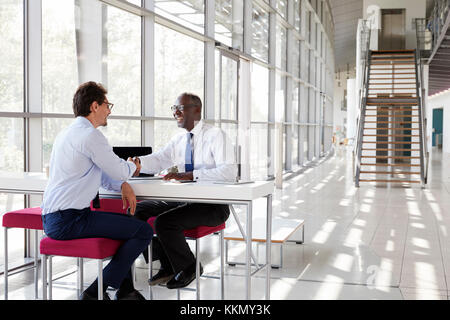 Two businessman shake hands during a meeting Stock Photo