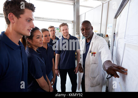 Engineer pointing to whiteboard while training apprentices Stock Photo