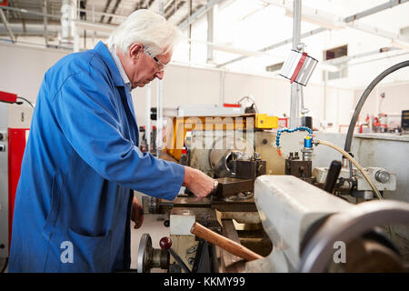 Senior engineer working in a factory, side view Stock Photo