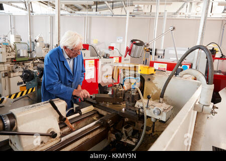 Senior engineer operating industrial machinery in a factory Stock Photo