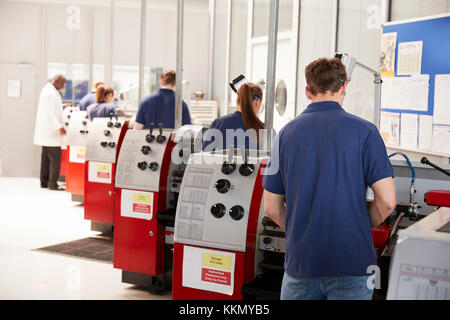 Foreman inspecting trainee engineers working in a factory Stock Photo