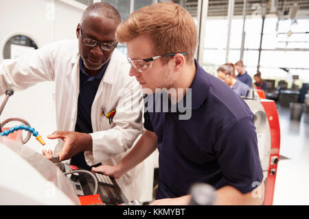 Engineer giving guidance to apprentice in factory, close up Stock Photo