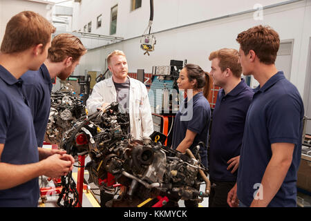 Apprentices studying car engines with a mechanic, close up Stock Photo