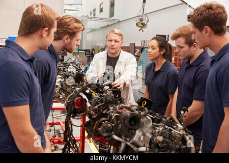 Mechanic showing parts of an engine to apprentices, close up Stock Photo