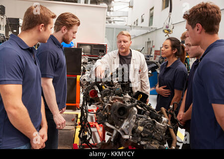 Mechanic showing parts of an engine to apprentices, close up Stock Photo