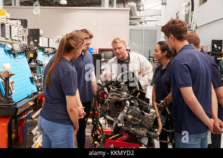 Car mechanic showing engines to apprentices Stock Photo