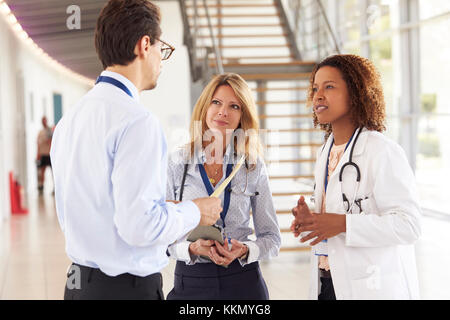 Three young male and female doctors in consultation Stock Photo