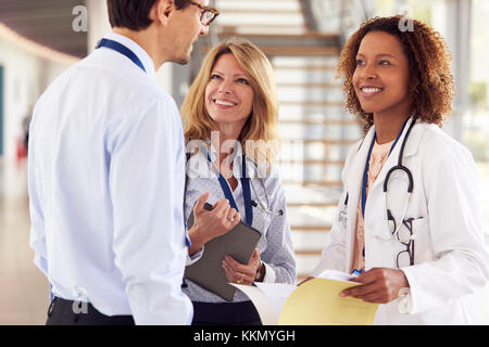 Three young male and female doctors in consultation Stock Photo