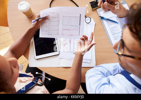 Overhead shot of doctors in consultation over patient notes Stock Photo