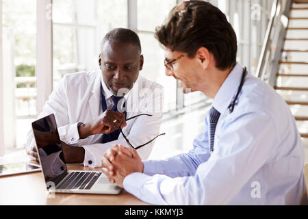Two senior healthcare workers in consultation using laptop Stock Photo