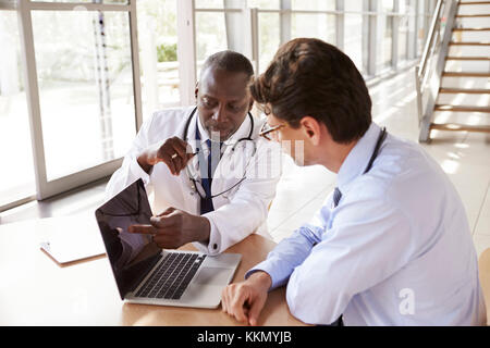 Two senior healthcare workers in consultation using laptop Stock Photo
