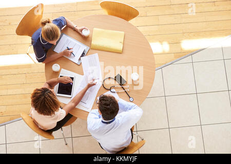 Three senior healthcare workers in a meeting, overhead view Stock Photo