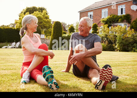 Healthy Senior Couple Exercising In Garden Together Stock Photo