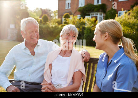 Nurse Talking To Senior Couple In Residential Care Home Stock Photo