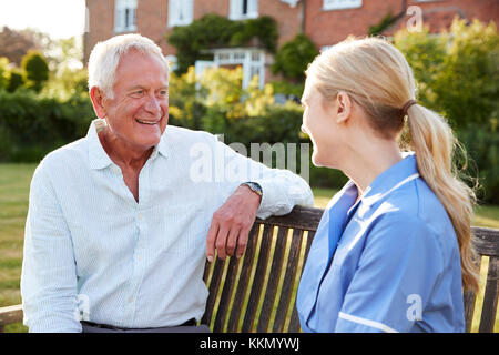 Nurse Talking To Senior Man In Residential Care Home Stock Photo