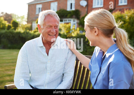 Nurse Talking To Senior Man In Residential Care Home Stock Photo