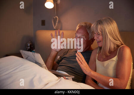 Senior Couple Using Laptop To Connect With Family For Video Call Stock Photo