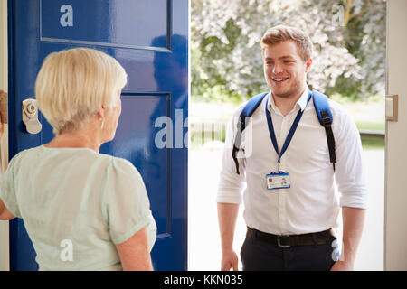 Senior woman greeting male care worker making home visit Stock Photo