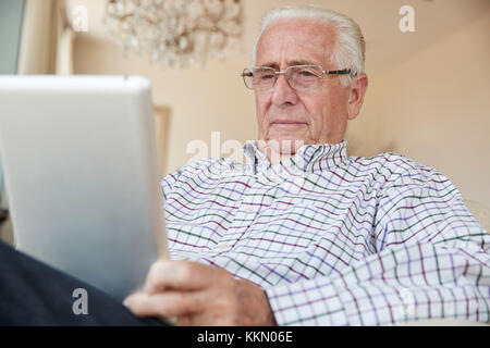 Senior man using a tablet computer at home, close up Stock Photo