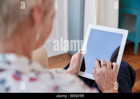 Senior woman using tablet computer, over shoulder view Stock Photo