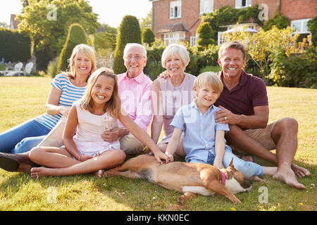 Multi generation family sitting on grass in the garden Stock Photo