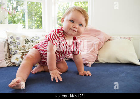 Baby Boy Sitting On Seat By Window Stock Photo