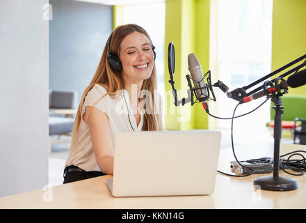 Happy young woman broadcasting in a studio, close up Stock Photo