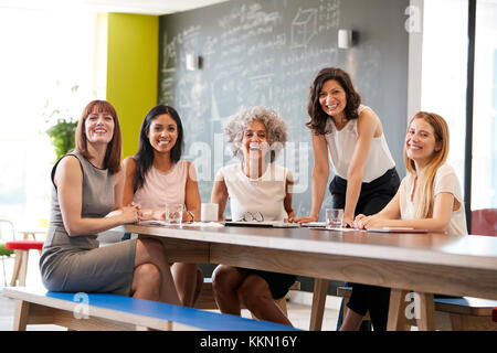 Happy female colleagues at a work meeting smiling to camera Stock Photo
