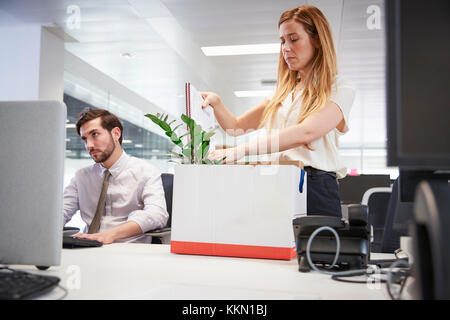 Fired female employee packing box of belongings in an office Stock Photo