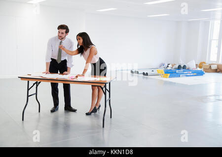 Businessman and woman discussing plans for office design Stock Photo