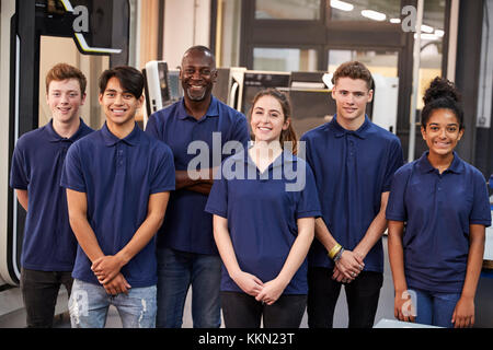 Portrait Of Engineer And Apprentices In Factory Stock Photo