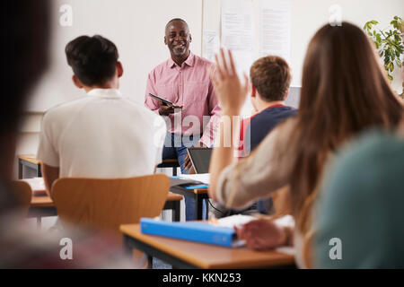 Rear View Of Female College Student Asking Question In Class Stock Photo