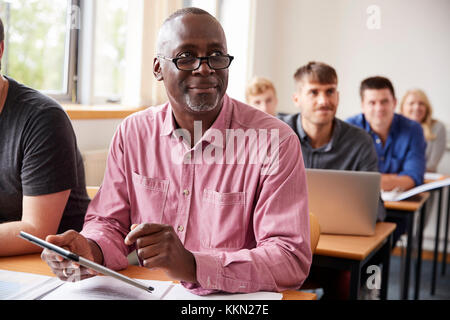 Mature Student Using Digital Tablet In Adult Education Class Stock Photo