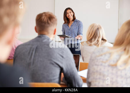 College Tutor With Digital Tablet Teaches Mature Students Stock Photo